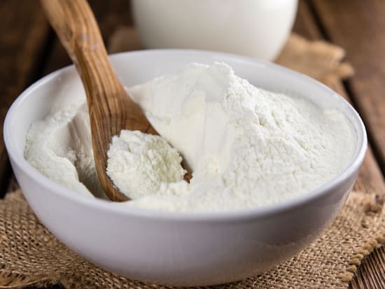 Photo of milk dairy protein powder in a wooden bowl